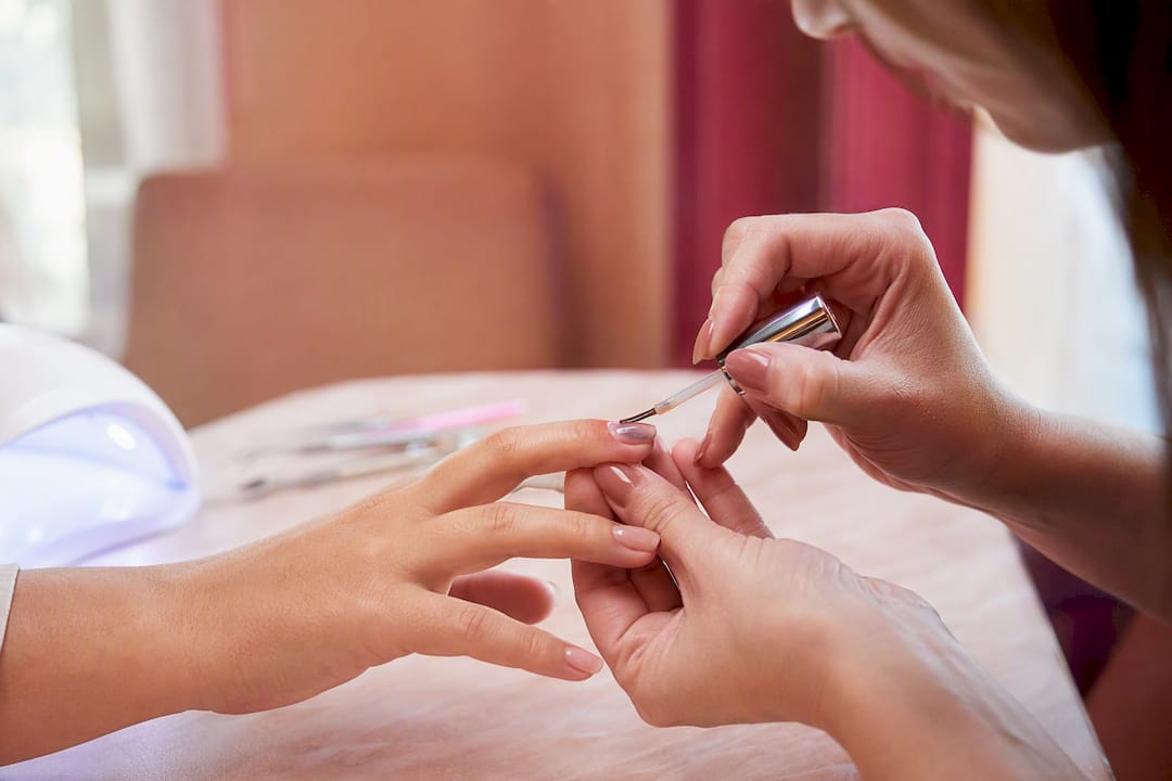 Close-up van het nauwkeurig aanbrengen van hard gel op de nagel met de hand